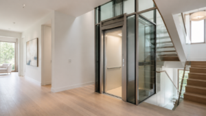Modern two-stop home elevator beside an open staircase in a bright private residence